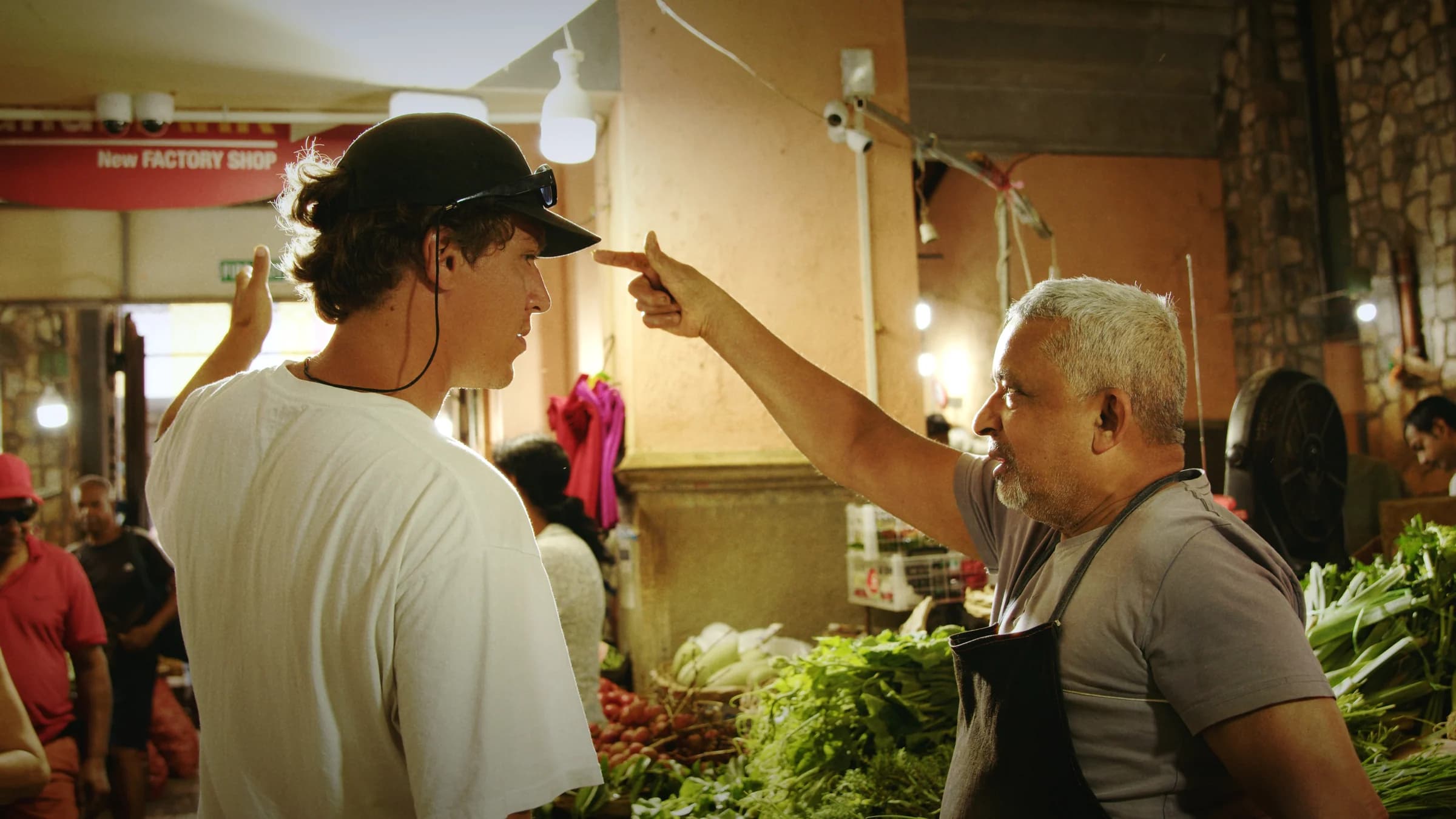 A guide and visitor in conversation at a vegetable stall