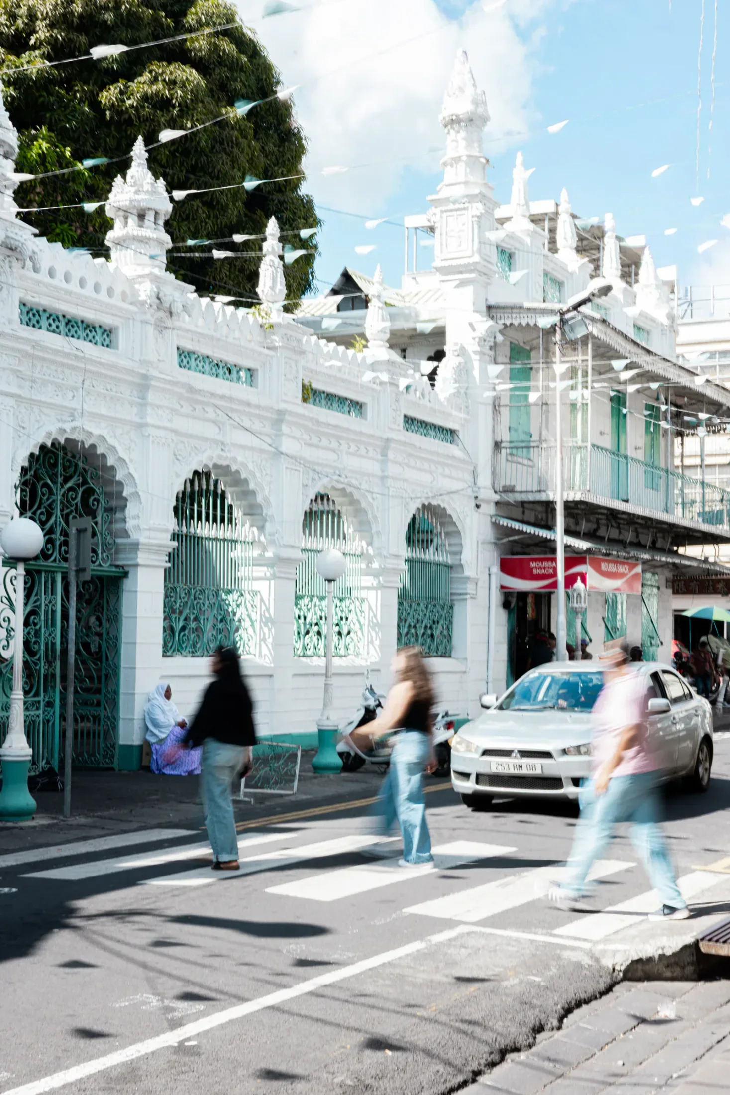 The white and green façade of Jummah Mosque beside a Port Louis street